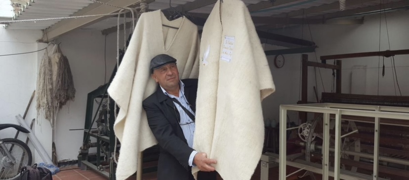 Artesano mostrando ruanas terminadas