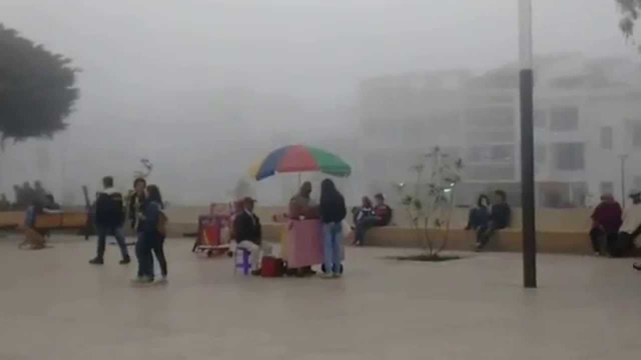 Vendedor ambulante intentando protegerse de la lluvia
